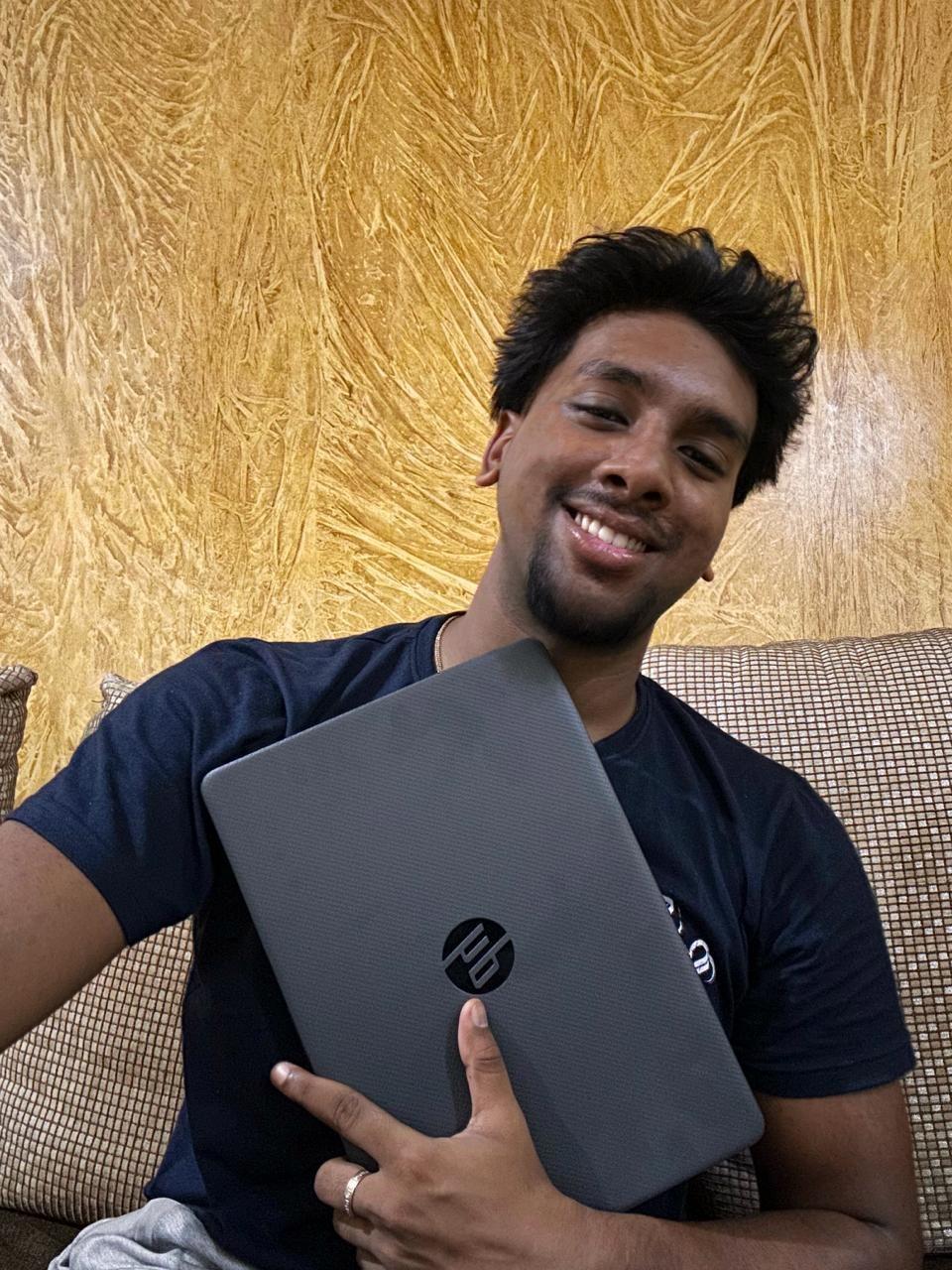 Jerovin Floyd Vincent Joseph holding his Aurora prize laptop